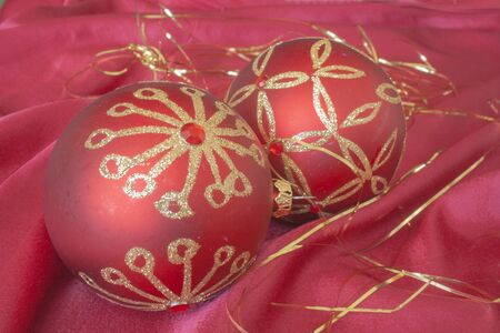 Decorative red balls on a red material as background.の写真素材