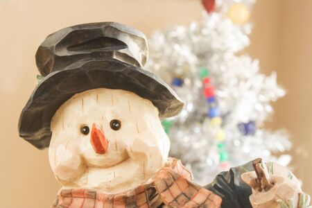 Puppet with a carrot nose and a white christmas tree behind.の写真素材