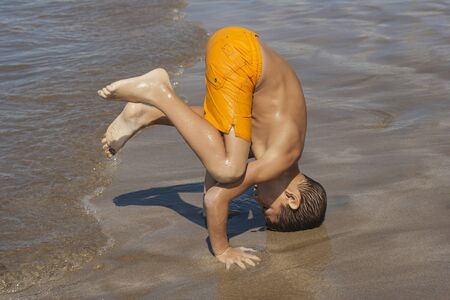 Child playing and doing exercises in the beachの写真素材