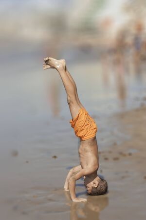 Child doing exercises and playing in the beach.with a blur backgroung.の写真素材