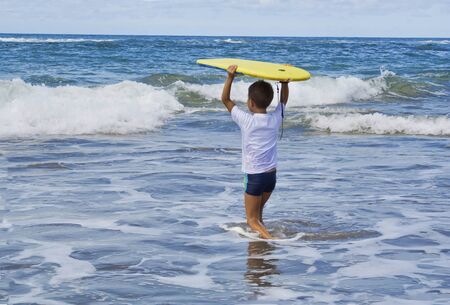 Child entering .the water to play with the wavesの写真素材