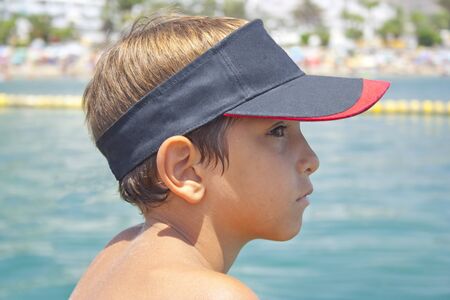 Child with a visor looking towards the open sea.の写真素材