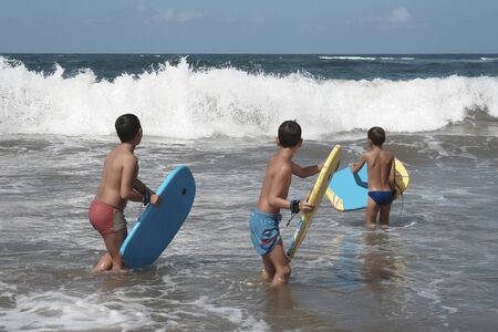 Boys with theirs surfing boards waiting for the waves.の写真素材