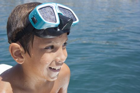 Child pretty wet with the underwater glasses on his head.の写真素材