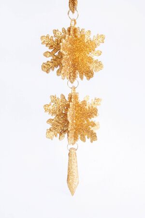 Hanging isolated golden christmas decoration in a white background.の写真素材