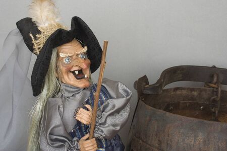 A naughty witch with a stick in her hand closed to her big pot.の写真素材