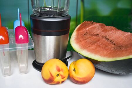 Fruits ad mixer on a tableの写真素材