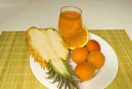 Fresh healthy juice of orange,pineapple and apricots.の写真素材