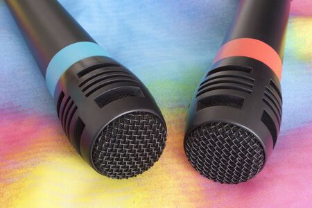 Karaoke microphones on top of a colorful material.の写真素材