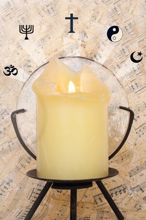 Lighted candle sorrounded for religious symbols.の写真素材