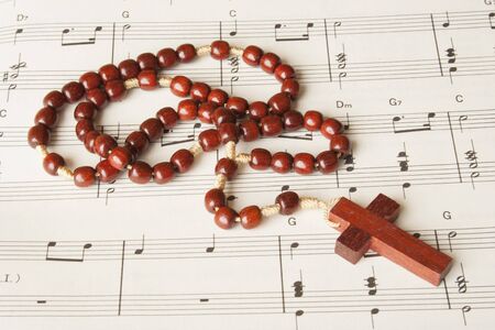 Wood rosary on a sheet of religious music.の写真素材