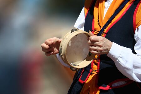 Woman playing the tambourine in a popular festival.の写真素材