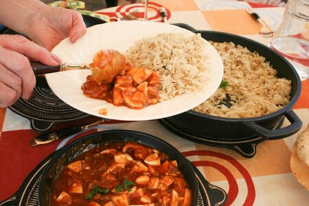 The host is serving the combined indian food plate.の写真素材