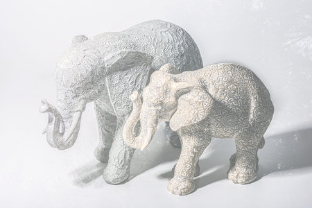 figurine of an elephant with a baby elephant on a white backgroundの写真素材