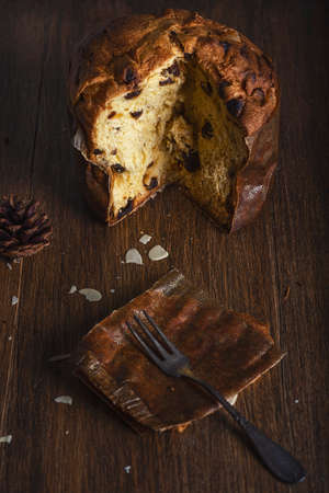 Panettone, traditional Italian Christmas cake with raisins on dark wooden backgroundの写真素材