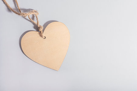Wooden heart with a rope on a gray backgroundの写真素材
