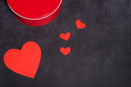 Gift box and red hearts, large and small, dark background