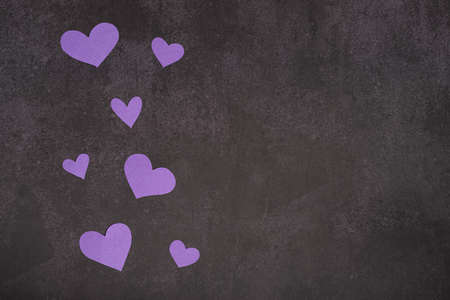 Small purple hearts on a dark background, copy spaceの写真素材