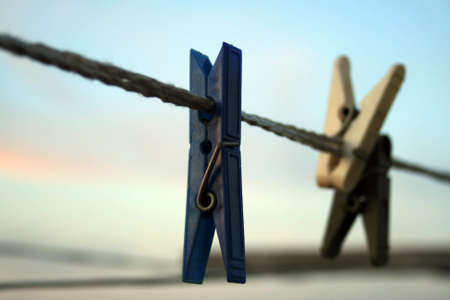 one blue clothespeg on the cord, and two clothespegs out of focusの写真素材