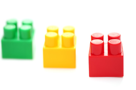 Red block piece in focus, green and yellow not in focus.Isolated on white backgroundの写真素材