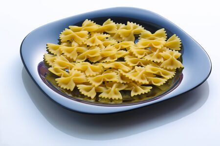 pasta in a black plate on white.Isolated on whiteの写真素材