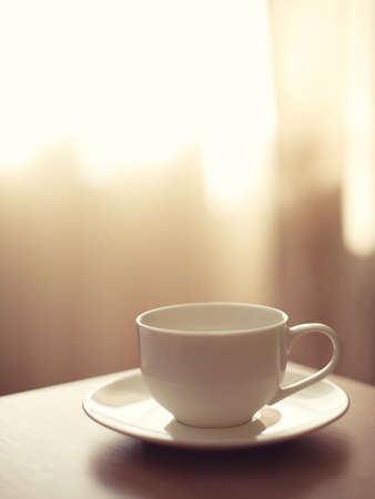 cup of coffee on blurred background. White cup on a saucerの写真素材