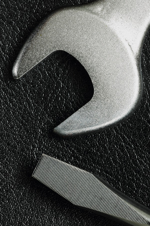 wrench spanner tool and screwdriver on black leather backgroundの写真素材
