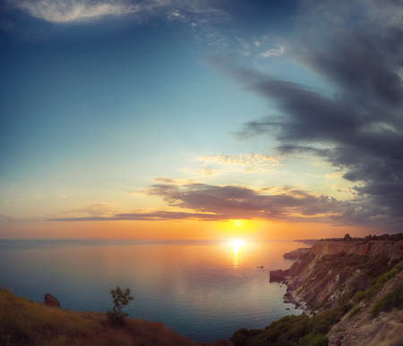 Dramatic sunset at cape fiolent with rocks and grass at foreground. Crimeaの写真素材