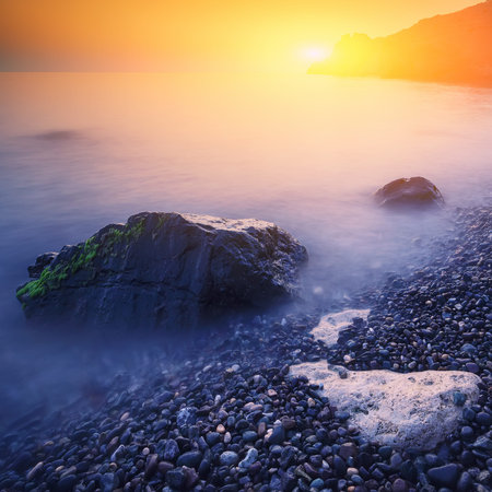 Seascape during sunset. Beautiful natural seascape at long exposure. Stones at foreground