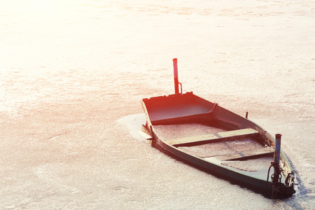 Frozen Into Ice Of River, Lake, Pond Old Wooden Boat. Abandoned Rowing Fishing Boat In Winter River. Forsaken Boatの写真素材