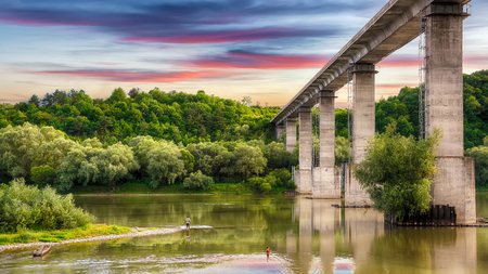 Huge arch  bridge built over Dnister river in Ukraine. Beautiful clouds in the sky over the river in Dnister Canyon. Ukraine. Europeの写真素材