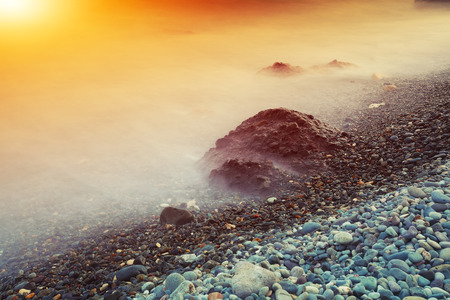 Seascape during sunset. Beautiful natural seascape at long exposure. Stones at foregroundの写真素材