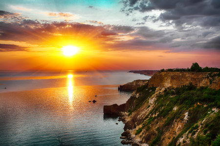 Dramatic sunset at cape Fiolent with bushes grass and rocks at foreground. Crimeaの写真素材