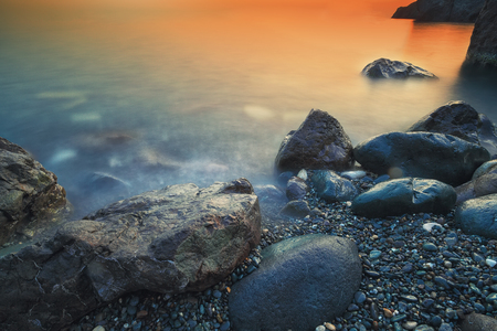 Seascape during sunset. Beautiful natural seascape at long exposure. Stones at foregroundの写真素材
