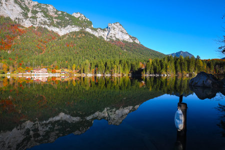 Fantastic autumn sunny day on Hintersee lake. Beautiful scene of mirror reflection in water of...
