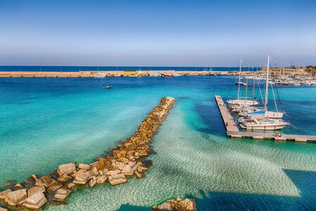 Several fishing boats at the Otranto harbour - coastal town in Puglia with turquoise sea. Italian vacation. Town Otranto, province of Lecce in the Salento peninsula, Puglia, Italyの写真素材