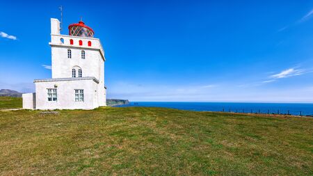 Landscape with white lighthouse at Cape Dyrholaey. Location: Cape Dyrholaey (Cape Portland), near Vik village, Island, Europeの写真素材