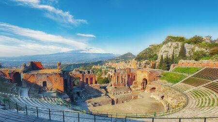 Ruins of ancient Greek theater in Taormina and Etna volcano in the background. Coast of Giardini-Naxos bay, Sicily, Italy, Europe.の写真素材