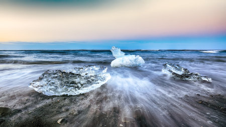 Incredible pieces of the iceberg sparkle on famous Diamond Beach at  Jokulsarlon lagoon during...