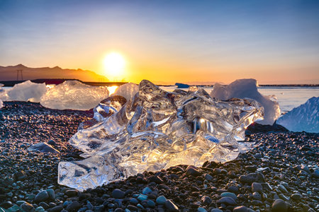 Incredible pieces of the iceberg sparkle on famous Diamond Beach at  Jokulsarlon lagoon during...