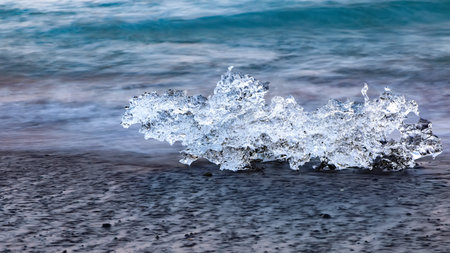 Incredible pieces of the iceberg sparkle on famous Diamond Beach at  Jokulsarlon lagoon during...