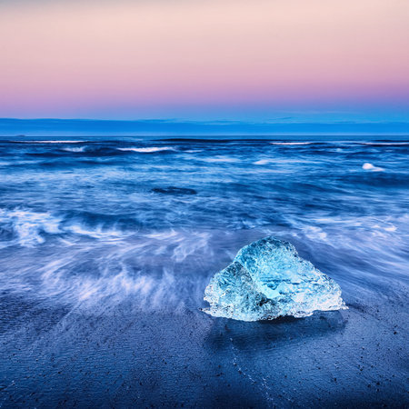 Incredible pieces of the iceberg sparkle on famous Diamond Beach at  Jokulsarlon lagoon during...