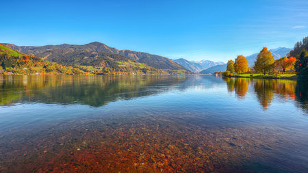 Spectacular autumn view of lake and trees in city park of Sell Am See. Fantastic sunny day over lake. Location:  Zell am See, Salzburger Land, Austria, Europeの写真素材