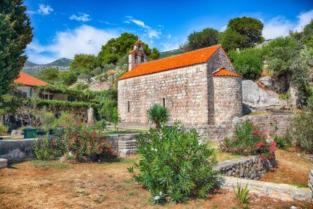Stone church with bell tower at Gradiste monastery near Buljarica, Montenegro. Churchyard and abbey near Adriatic sea. Location: Buljarica, Montenegro, Europeの写真素材