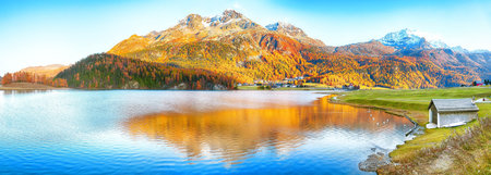 Awesome autumn panorama of Silvaplana lake and Surlej village. Location: Silvaplana, Maloya...