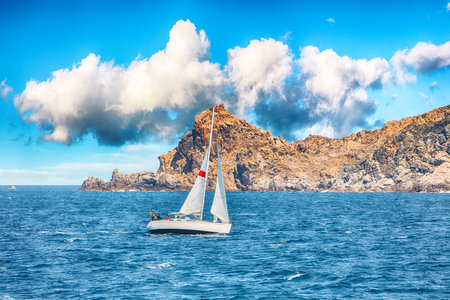 Splendid view of sailboat sailing near the cliffs of Santa Teresa Gallura. Popular travel destination of Mediterranean sea. Location: Santa Teresa Gallura, Province of Sassari, Sardinia, Italy, Europeの写真素材