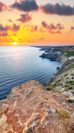 Dramatic sunset at cape Fiolent with bushes grass and rocks at foreground. Crimeaの写真素材