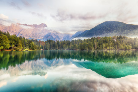 Incredible view of sunset over Fusine lake with Mangart peak on background. Popular travel destination of Julian Alps. Location: Tarvisio comune , Province of Udine, Italy, Europeの写真素材