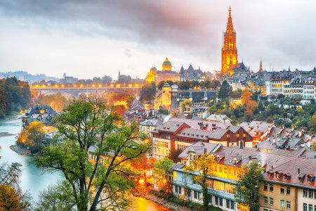 Amazing autumn view of Bern city on  Aare river during evening with Cathedral of Bern on background....