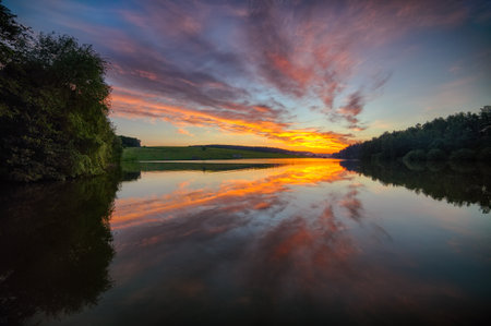 Amazing Dramatic sunset over the lake. Sky and clouds reflection on Lakeの写真素材